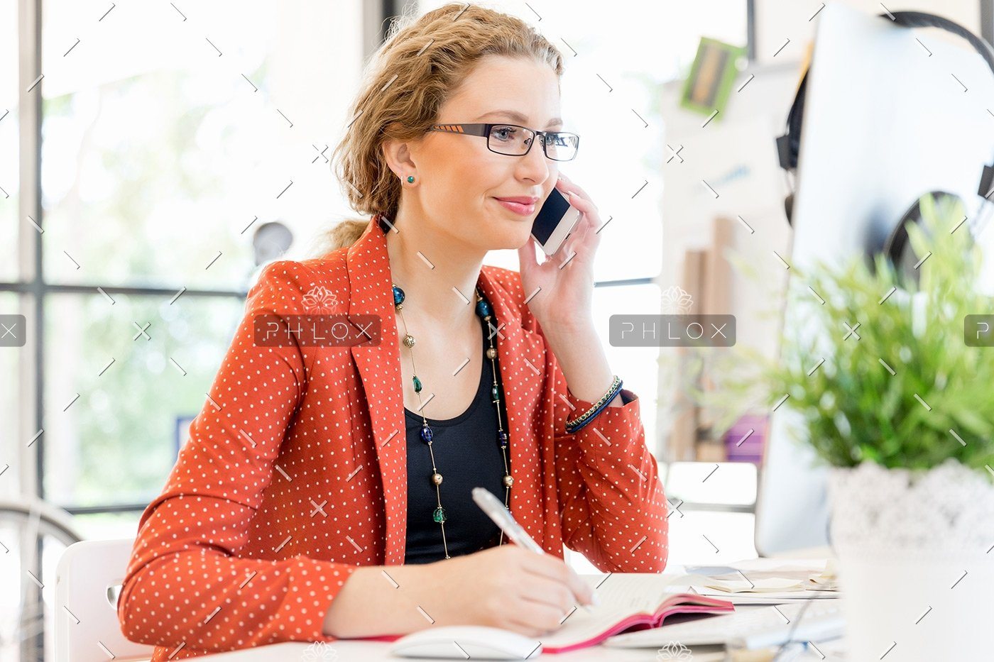 demo-attachment-138-young-woman-holding-mobile-phone-in-office-PE9ARDR